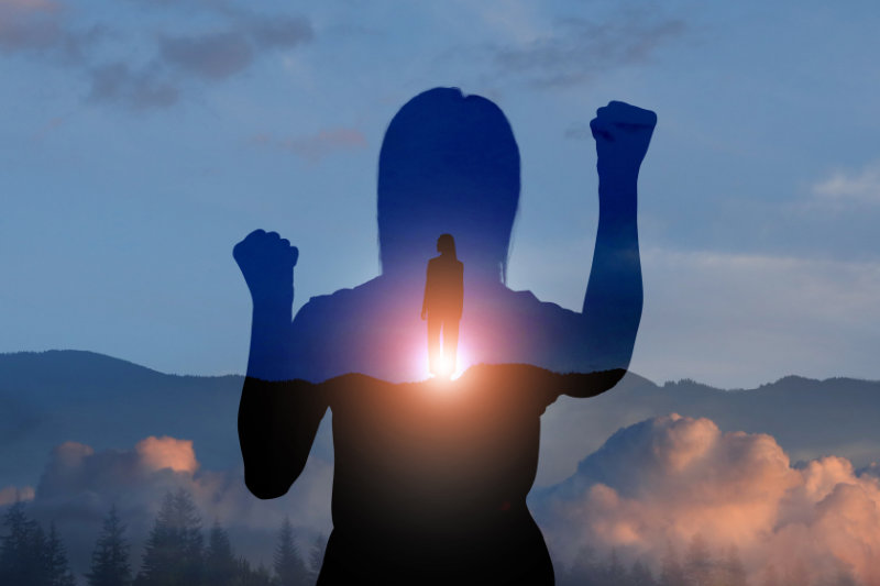 Hope. Silhouettes of woman and winner on top of mountain at sunrise, double exposure