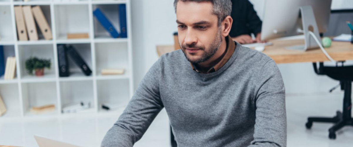 handsome businessman working with laptop computer in office