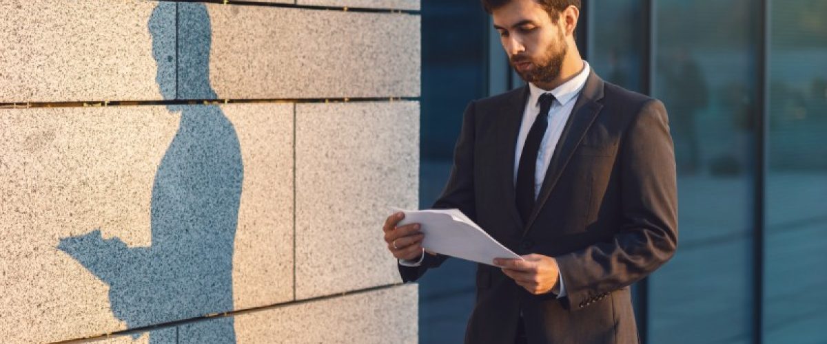 serious-young-businessman-in-a-classic-suit-readin-2022-12-16-11-31-36-utc_fet